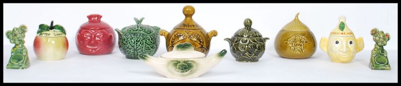 A collection of vintage 20th century ceramic condiment jars with faces to include apple sauce, mint,