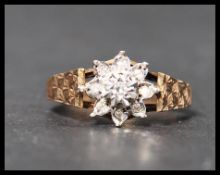 A hallmarked 9ct gold diamond cluster ring having a central illusion set diamond with a halo of