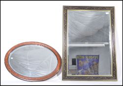 A 20th century ebonised frame with gilt overlay bevel edge wall mirror of rectangular form