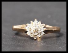 A hallmarked 9ct gold and diamond cluster ring. Weight 2.1g. Size M.5.