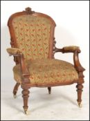 A Victorian mahogany aesthetic movement armchair. Raised on turned legs with overstuffed seat and
