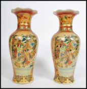 A pair of 20th century Chinese export ware famille rose vases decorated with typical scenes and of