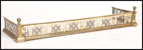 A 19th century Victorian brass fire fender having a stepped flared apron with pierced geometric