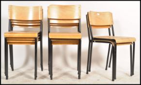 A collection of 16 retro panel wood and tubular metal stacking chairs. Each on ebonised tubular