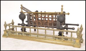A 19th century Victorian brass fire fender of classical form with companion set along with a