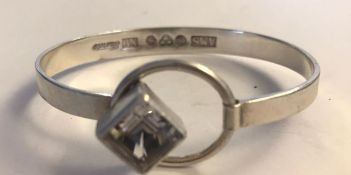 A hallmarked Arvo Saarela Swedish silver modernist bracelet bangle set with a cushion cut white