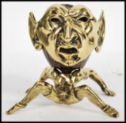 A 19th century brass treen match strike, the match strike in the form of a grotesque Pixie / Imp,