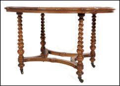 A 19th century Victorian walnut library table raised on brass castors with barley twist columns