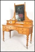 A Victorian 19th century satin birch wood duchess dressing table being raised on turned legs with