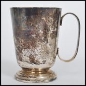 A hallmarked mid 20th century silver tankard cup raised on a circular base with C handle bearing