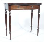 A 20th century mahogany card table having fold over top with green circular baize raised on reeded