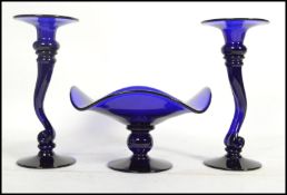 A group of three Bristol Blue glass items to include a pair of vases on circular bases with scrolled