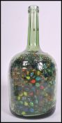 A large collection of vintage 20th century glass marbles contained within a large glass bottle