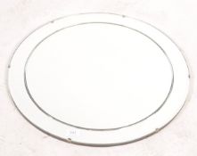 A 1930's Art Deco circular frameless mirror with ridged detaling. Wooden back panel with chain.