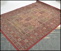 A large vintage Persian Islamic carpet rug having a red ground with geometric borders and
