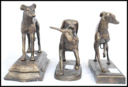 A collection of three cast metal bronze effect figurines of dogs to include a bitch and a dog