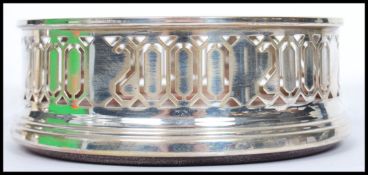 A continental silver hallmarked W I Broadway & Co silver and  turned wood wine coaster. Fret pierced