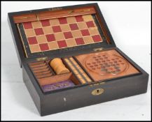 A 19th century games compendium set housed within a wooden case to include chess, draughts,