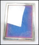 A large silver hallmarked easel picture frame, rope border, blue velvet back with central glass