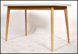 A fabulous retro vintage mid 20th century dining table raised on beech splayed legs, the table