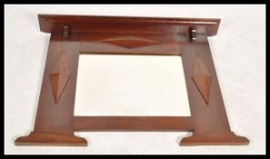 A Victorian mahogany overmantel wall mirror in the Arts & Crafts manner. The central bevelled mirror