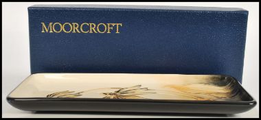 A Moorcroft ceramic pin tray of rectangular form tube lined decorated with flowers complete in