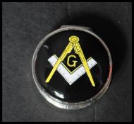 A 925 silver pill box having an enamel masonic motif to lid. Marked 925. Weight 16.9g. Measures 2.