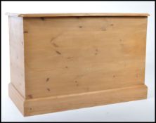 A contemporary pine blanket box raised on plinth base with panelled sides and hinged top opening