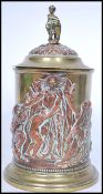 An early 20th century copper and brass biscuit tin / tobacco jar having a cherub and shield final