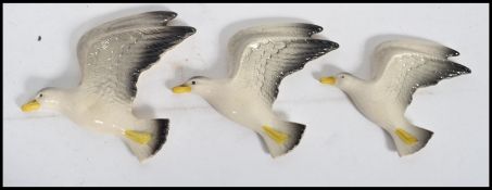 A group of three graduating ceramic wall plaques modelled as seagulls in flight impressed mark to