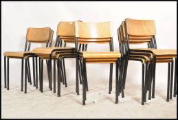 A collection of 13 retro panel wood and tubular metal stacking chairs. Each on ebonised tubular