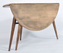 An Ercol retro 1970's drop leaf circular coffee - occasional table by Ercol raised on tapered legs w