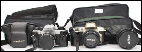 A Nikon F60 camera in carry case with two lenses a 35-70mm and 70-210mm along with a Voigtlander VSL