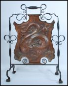 A 19th century Victorian Arts and Crafts wrought iron and copper fire screen depicting a dragon in