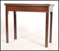 A 19th century mahogany card / games table being raised on squared legs with flip over games table