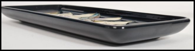 A Moorcroft ceramic pin tray of rectangular form tube lined decorated with flowers in the Sophie