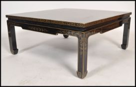 An Oriental Chinese black lacquered low coffee table depicting scenes of flowers and birds with gilt