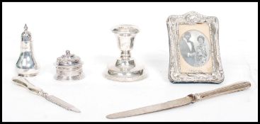 A collection of silver hallmarked items to include a pepper cruet, candle stick, easel picture