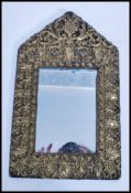 A cushion mirror dating to the 19th century  with pressed brass mounts, the crest with a armorial