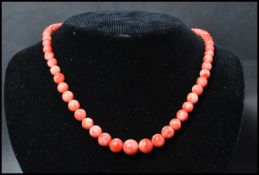 A vintage angel skin coral necklace. Each bead carved and strung set to a gilt barrel clasp.