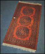 A 20th century Kelim woolen rug / runner , on red ground with a central medallion, inner border with