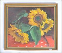 A 20th century still life oil on canvas painting of sunflowers set within a gilt frame and signed to