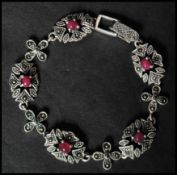 A 925 silver  Art Nouveau style bracelet set with ruby cabochons and marcasite having a clip