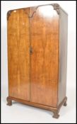 A 1930's Art Deco walnut bachelors wardrobe being raised on shaped leg plinth base with double doors