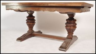 An early 20th century oversized draw leaf French refectory dining table being raised on carved cup