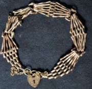A hallmarked 9ct gold heart padlock clasp bracelet chain with safety chain. Weighs 9.1 grams.