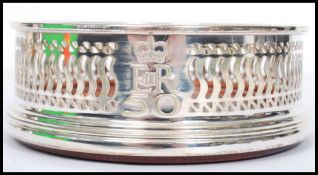 A continental silver hallmarked W I Broadway & Co silver and  turned wood wine coaster. Fret pierced