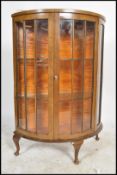 A 1930's Art Deco walnut demi lune display cabine being raised on cabriole legs with pad feet having