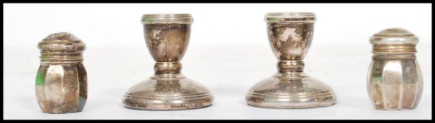 A pair of silver hallmarked stub candle sticks along with a small silver hallmarked pair of cruets