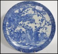 A 19th century blue and white Chinese ceramic charge plate depicting domestic scenes of elders